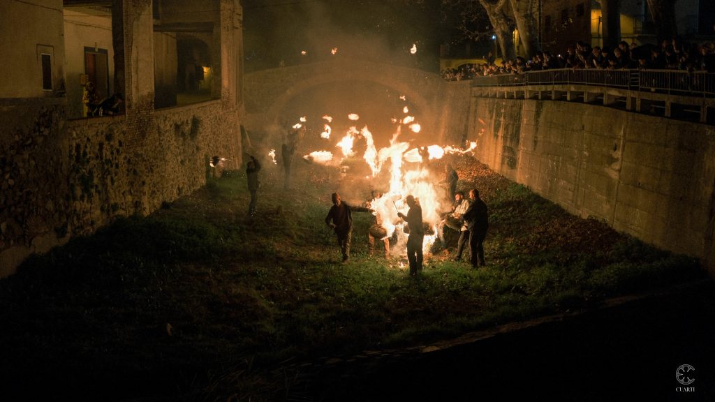 El pont vell il·luminat per l'argilaga cremant i les fogueres en la tercera edició de l'Encesa de l'Arbre de Nadal de Porrera.
